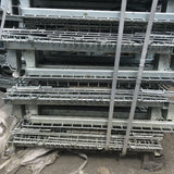 Used unpainted collapsible metal pallet cages stacked up.