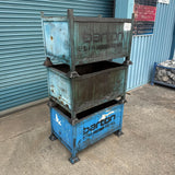 A stacked set of three weathered blue and  metal stillage bins with Barton branding.