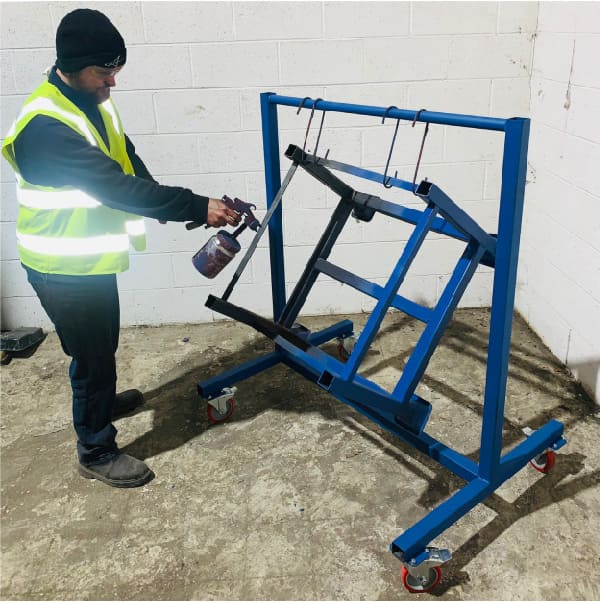 Photo of mobile paint drying trolley being used to spray paint products